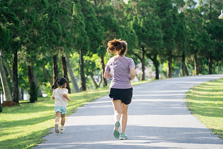 母亲和女儿跑步者在公园里慢跑 晚上 家庭活动 穿着运动服的母子俩正在跑步 玩得很开心短跑训练阳光母性享受赛跑者乐趣孩子女士运动装图片