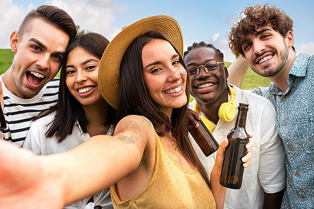 快乐的多种族朋友群体在大自然中享受一些户外啤酒时采取自拍 看镜头图片