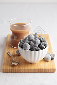 在白碗和木制板上 咖啡加酒盐咸沙尔米亚基铵盐黑色桌子糖果食物氯化物图片