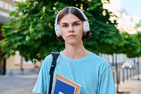 有教科书在户外看照相机的重度少年男学生青年街道发型青少年成人快乐青春期背包男生城市图片