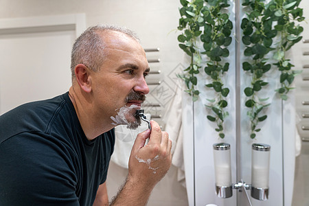 早上洗手间用泡沫擦刮剃刀的人奶油皮肤男性浴室护理胡须头发隔断刮胡子成人图片