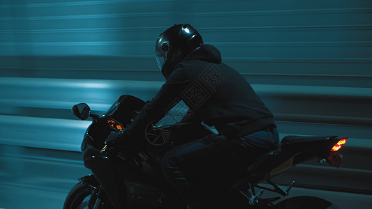 一个人晚上骑着运动摩托车穿过城市 在城里过夜旅行男人驾驶车轮自行车活动速度发动机交通车辆图片