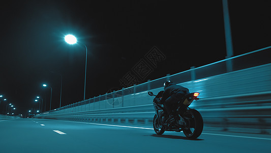 一个人骑运动摩托车在夜行的夜间赛道上辉光男人旅行乐趣头盔发动机车辆骑士运输城市图片