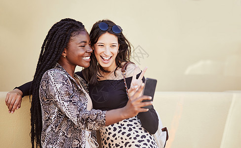 两位多种族女性朋友在城里共度时间 在智能手机上为社交媒体拍照  Twitter  foFinland whit_broom图片