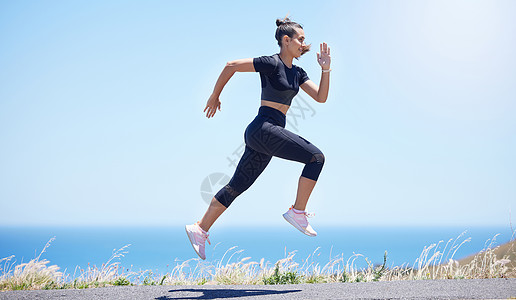 年轻的混种女子在空中跳跃时 在其日常锻炼中跑出户外的年青混合种族跑步成人训练运动街道身体女性太阳女士调子图片