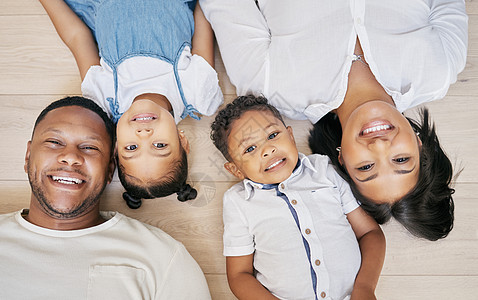 快乐的混血家庭 两个孩子一起躺在地板上 从上面在家里亲密无间 弟弟妹妹和父母共度时光图片