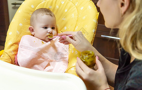 妈妈给婴儿喂蔬菜 有选择的焦点女士儿子椅子快乐勺子生长饮食母亲家庭横幅图片