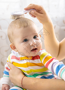 母亲正在梳小宝宝的头发 有选择地集中注意力快乐女士女孩生活身体新生梳子乐趣家庭横幅图片