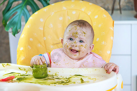 小宝宝自己吃西兰花 有选择的专注父母女孩蔬菜午餐快乐勺子孩子桌子横幅微笑图片