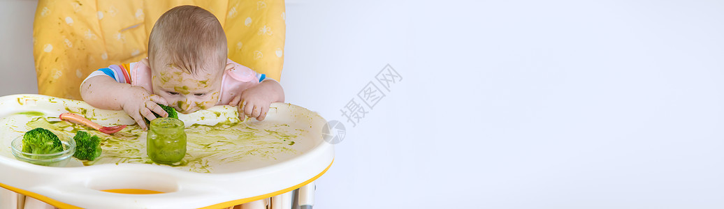小宝宝自己吃西兰花 有选择的专注桌子母亲孩子茶匙勺子午餐女孩营养食物微笑图片