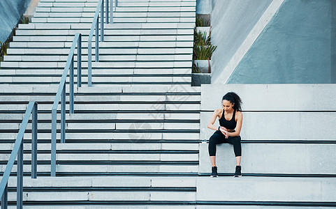 检查她的进度 全程拍摄 一个有吸引力的年轻女运动员在城外锻炼活动的照片图片