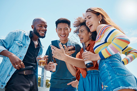一群性格开朗的年轻朋友一起站在外面 用手机自拍和社交媒体 微笑的男女在屋顶周末派对上社交和庆祝图片