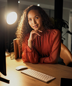 成功完全取决于您想要它的程度 一个自信的年轻女商务人士晚上在办公室工作时坐在办公桌前的画像图片