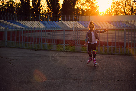 女孩在公园里骑滑雪鞋快乐闲暇冰鞋幸福微笑城市滑冰童年滚筒头盔图片