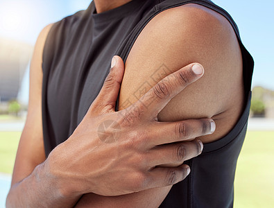 非洲裔美国运动员在训练时遭受肩痛的特写镜头 放大了一个不知名的黑人男子 他握着并揉着酸痛的手臂 过度劳累的肌肉导致紧张图片