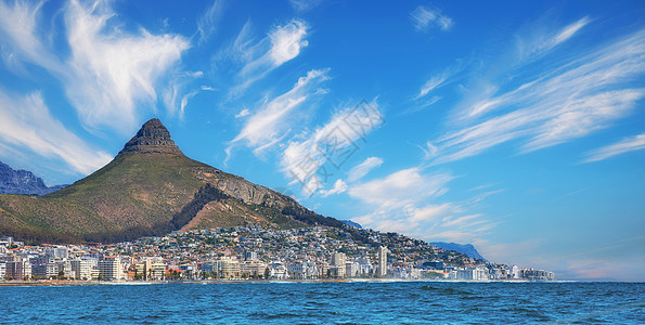 在南非开普敦海角复制空间 全景海景 云彩 蓝天 酒店和公寓楼 狮子头山俯瞰美丽的蓝色海洋半岛图片