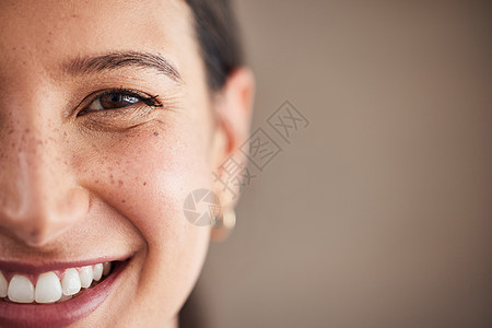 美丽的混血女人微笑着洁白的牙齿的脸 一个女人脸上的肖像 棕色的眼睛和雀斑与复制空间合影 牙齿健康和口腔卫生图片