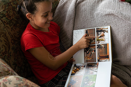 一个小女孩在客厅里 看着一张相片专辑照片孩子乐趣沙发女性女儿童年男孩们母亲学习图片