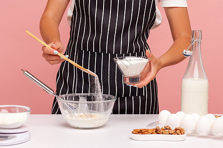 以粉红色背景为年轻女性做室内烹饪产品面包师甜点蛋糕厨师职业膳食美食烘烤面粉图片
