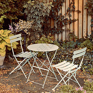 秋季 庭院金属椅和桌子位于家中宁静 宁静 郁郁葱葱的私人后院 庭院家具位于户外空间 座位位于带灌木植物的空旷而宁静的花园中图片
