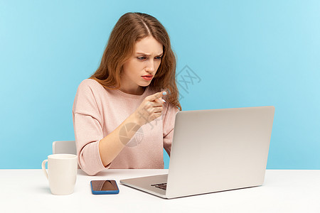 情感年轻女性在蓝背景的笔记本电脑上工作自由职业者人士办公室手势告诫蓝色视频警报电话商务图片