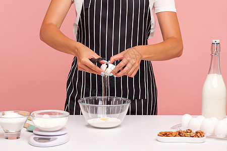 以粉红色背景为年轻女性做室内烹饪职业美食甜点膳食蛋糕营养馅饼烘烤蛋黄饼干图片