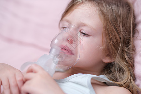 小caucasians女孩用特殊面具吸入和呼吸图片