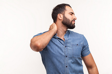 带着灰色背景的有感情的年轻胡子男人肌肉肩膀脖子男性焦虑紧张整骨师背痛按摩拉丁图片