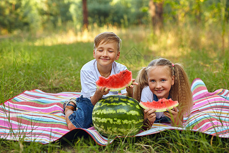 可爱的孩子在花园里吃西瓜男生野餐水果朋友孩子们营养食物花园家庭女孩图片