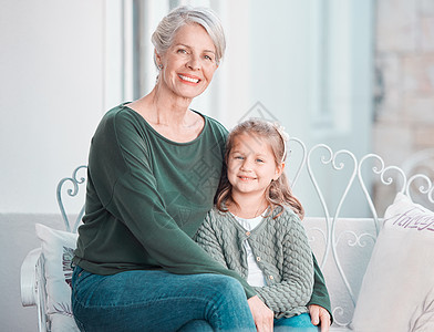 微笑可爱的小女孩和她的祖母坐在一起 同时在家里与她相处 向孙女表达爱意的美丽成熟白人女性图片