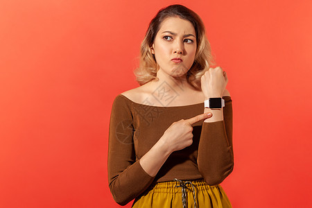 带着橙色背景的年轻情感女性屏幕展示焦虑女士小时手势智能手表广告手腕图片