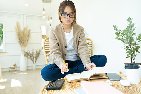 年轻的拼图学生在看一本坐在椅子上的书学习中学文学外貌家教青少年课堂校园家庭作业作坊图片