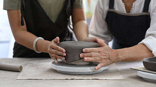 年轻女陶师和成年女子在陶艺车间用泥土制陶瓷锅 活动 手工艺 爱好概念图片