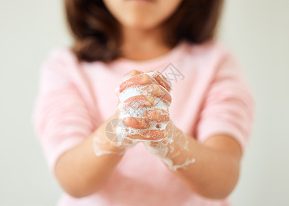 一个小女孩在家中浴室用肥皂洗手的近距离镜头中被拍到 她拿着肥皂洗手图片