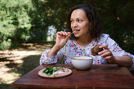 吃乌克兰国菜 — 传统罗宋汤 在乡下享用午餐的迷人多民族女性图片