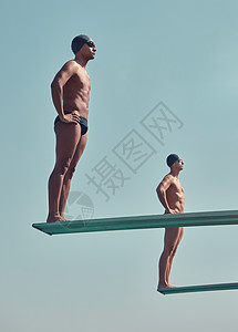 两名英俊的年轻男运动员 站在外面潜水板上 拍到一整场球赛图片