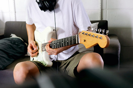 玩电子吉他的人男人艺术家娱乐音乐乐器男性岩石音乐会沙发房间图片