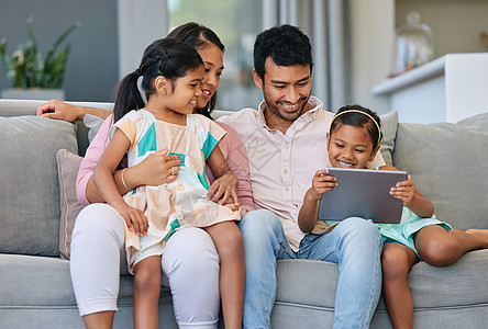 科技可以把家庭凝聚在一起 一个年轻的家庭在使用数字平板电脑的同时放松了起来图片