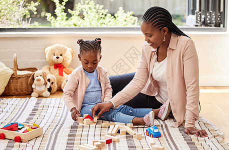 一个小女孩在家里和她妈妈玩砖块游戏 那样你还能做什么呢? 她是个小姑娘图片