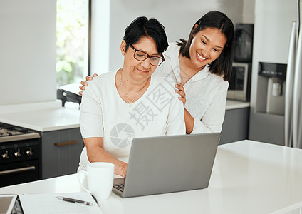 我的女儿 我的守护者 一名年轻女子在家中处理财务时与她年迈的母亲一起使用笔记本电脑图片