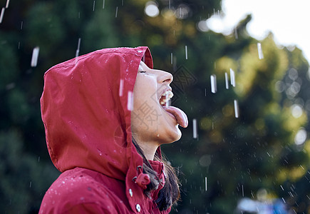 我觉得我又回到了小时候 下雨就是这样 一个年轻的女人伸出舌头感受外面的雨图片