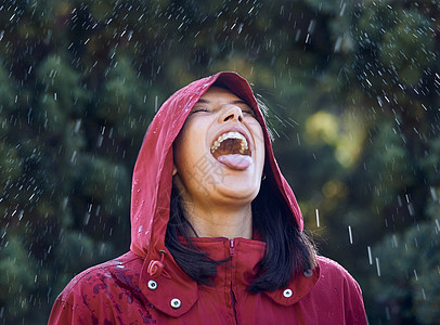 一位年轻女子伸出舌头感受外面的雨声 在她面前露出她的舌头图片