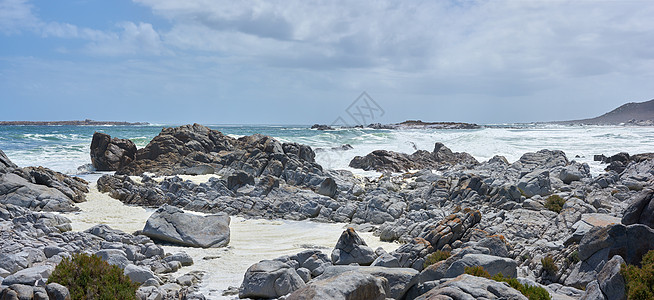 开普敦海滩的岩石海岸线 阴云密布 有岩石的岸在有一些波浪的海洋 在寒冷的日子里 在岩石池边的山海岩石海岸图片