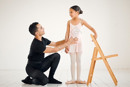 芭蕾舞老师协助一位学生在舞蹈演播室担任该职 她对芭蕾舞女郎充满信心图片