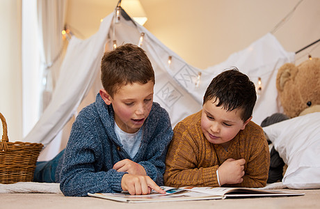 童话书两个兄弟在家里的毯子堡下 一起读一本书 他们很享受童话故事时光呢 (笑声)背景