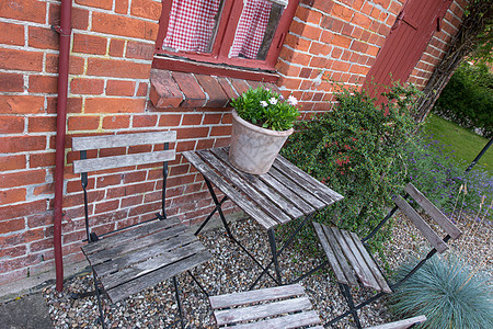 丹麦的一个私人家庭花园里有木制庭院椅和桌子 里面种着新鲜的绿色盆栽植物 瑞典宁静 祥和 祥和的后院 春天在僻静的地方放松背景图片