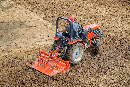 使用小型拖拉机的农民为草坪解开土壤 土地耕种 地面平整花园农业机械坑洞舵柄栽培耕作耕地工作场地农业图片