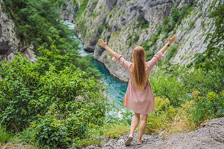 在峡谷间流动的莫拉卡河绿松石色最纯净的水域背景下的女游客 周游黑山概念岩石照片荒野假期航空旅游悬崖远足山脉森林图片