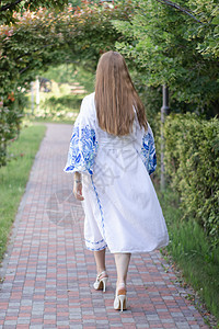 露天公园内穿着蓝色国家传统刺绣衬衣的乌克兰青年妇女肖像 照片来自新娘民间戏服衣服衬衫女孩装饰品场地文化绣花图片