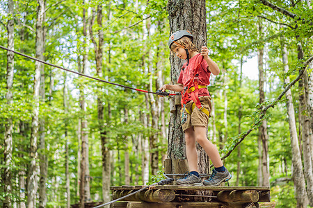 戴头盔的快乐儿童 健康健康的少年学校男孩 暑假在爬山冒险公园享受活动的权利冒险娱乐安全孩子男生风险游客绳索运动育儿图片